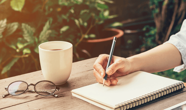 woman-journaling-with-large-cup-coffee